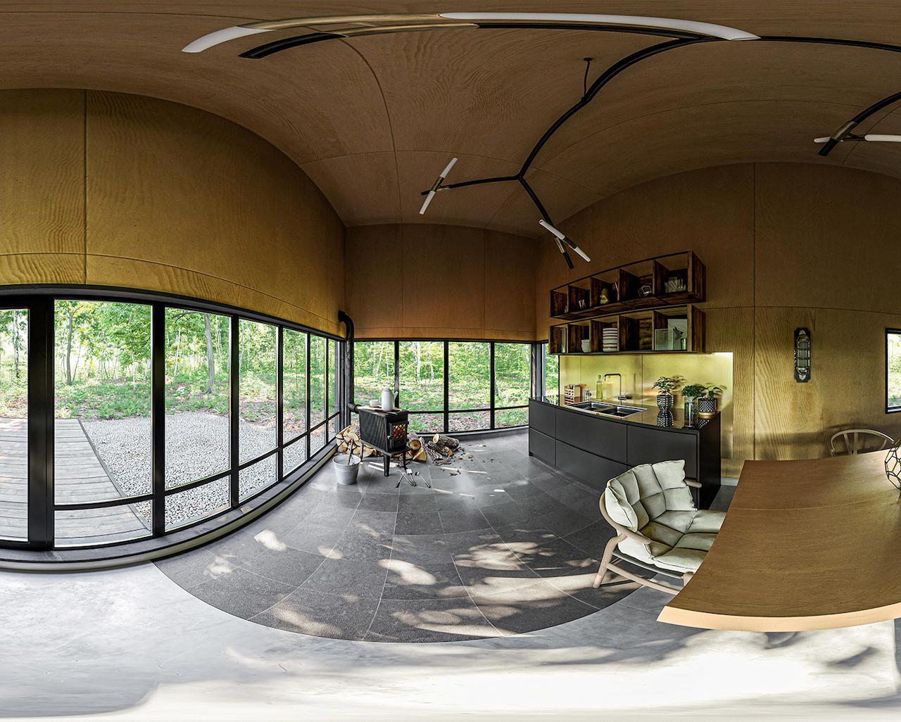 Forest Cabin interior 360° panorama — wood-lined space with panoramic glazing, modern kitchen, dining table, and forest view outside.